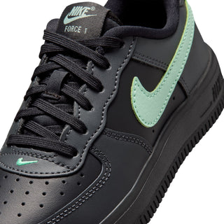 Close-up of kids black Nike Force 1 sneaker with mint green swoosh and laces