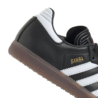 Kids black and white sneakers, white stripes and gum outsole, lace-up side view