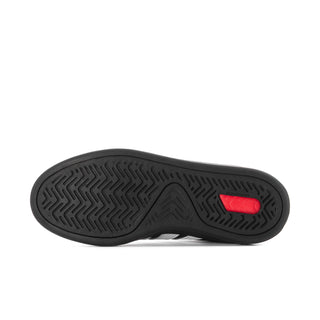 Black sneaker outsole with red traction insert and textured tread pattern