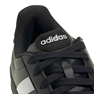Close-up of black sneaker upper with adidas tongue label and lace details
