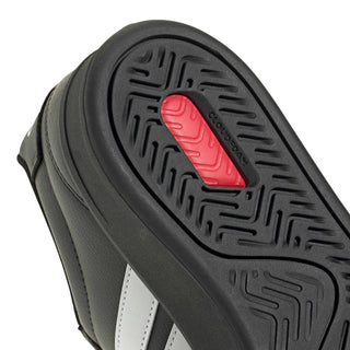 Close-up of black outsole with red insert and molded traction pattern