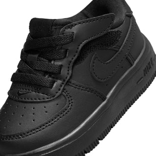 Toddler black low-top sneaker detail: hook-and-loop strap, stitched panels, Swoosh logo