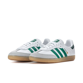 White womens sneakers with green triple stripes and gum outsole, side view