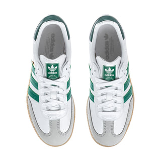 White womens sneakers with green stripes, lace-up front, and gum sole