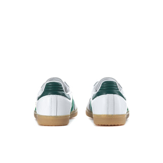 Pair of white womens sneakers with green heel detail and gum rubber sole