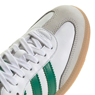 Close-up of white womens sneaker with green stripe detail and white laces