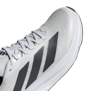 Men's white running shoe close-up, black stripe detail and textured upper