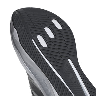 Men's running shoe outsole close-up, dark tread with lighter grip rails