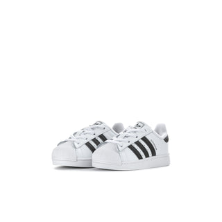 Toddler sneakers pair, white with black triple stripes and lace closure