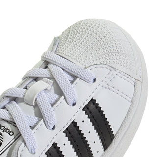 Toddler sneaker close-up: white leather-look upper with black stripes
