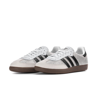 Pair of womens rhinestone low-top sneakers in white with black adidas stripes