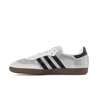Side view of white rhinestone sneakers with black adidas stripes and gum sole