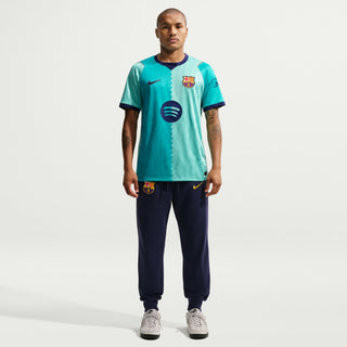 Men's teal FC Barcelona soccer jersey with crest, diagonal pattern, and short sleeves