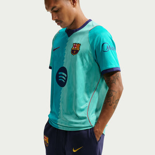 Men's teal soccer jersey with FC Barcelona crest and black circular sponsor graphic