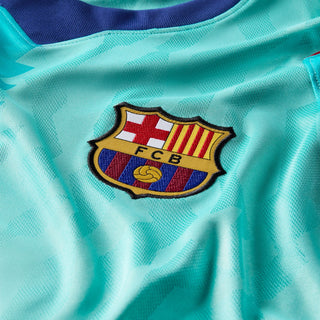 FC Barcelona crest patch on teal soccer jersey fabric