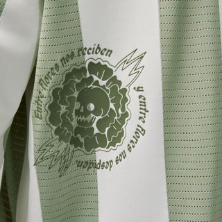 Men's goalie top close-up: green lion-style crest and curved text print on stripe
