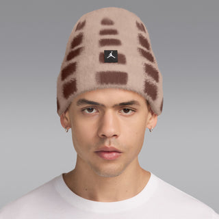 Fuzzy beanie with brown-and-cream geometric blocks, black logo patch, worn by model