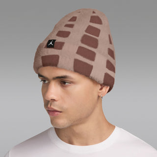 Fuzzy beanie in brown-and-cream geometric blocks with black logo patch, side view