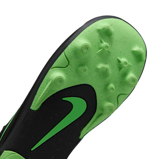 Kids cleat outsole close-up: black and green rubber with stud tread pattern