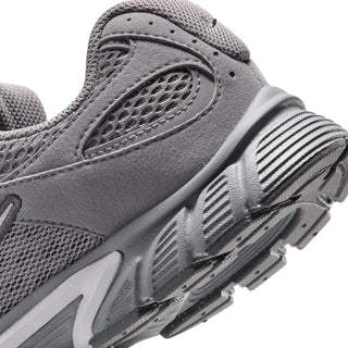 Close-up of youth dark gray sneaker side with mesh texture and striped midsole graphics