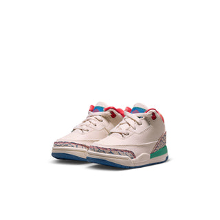 Toddler low-top sneaker angled view in cream with red collar and multicolor side panel