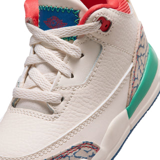 Toddler sneaker close-up: cream leather laces, red eyelet, and woven side detail