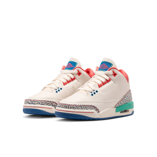 Youth sneakers angled view with white uppers, red collar, blue lace eyelets, teal sole