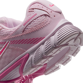 Close-up of youth sneaker side and outsole tread with pink stripe and Nike logo