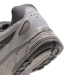 Men's sneaker toe and side close-up in light bone and gray with stacked sole