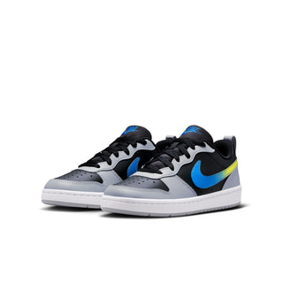 Pair of youth low-top sneakers in light gray and black with blue swoosh and yellow stripe