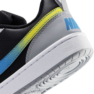 Close-up youth sneaker side and sole: yellow accent stitching, gray outsole tread
