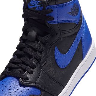 Close-up of black high-top sneaker with royal blue swoosh and lace detail