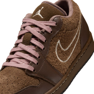 Womens sneaker close-up: brown suede, pink lace-up, white swoosh and Jumpman logo