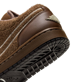Womens sneaker sole and side close-up with brown upper, stitching, and tread pattern