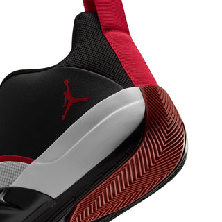 Men's sneaker heel close-up with red strap, black outsole and red tread