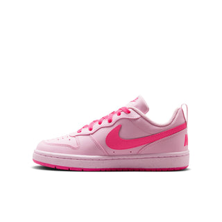 Youth pink low-top sneaker side view with pink swoosh, laces, and white midsole