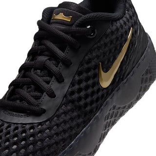Close-up of youth black sneaker upper with gold swoosh and textured knit pattern