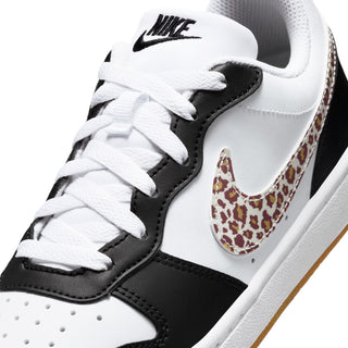 Youth low-top sneaker close-up, white laces with black accents and leopard Swoosh