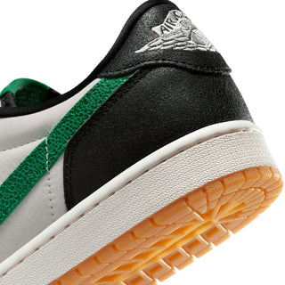 Close-up of black and green low-top sneaker with white midsole and gum-brown outsole.