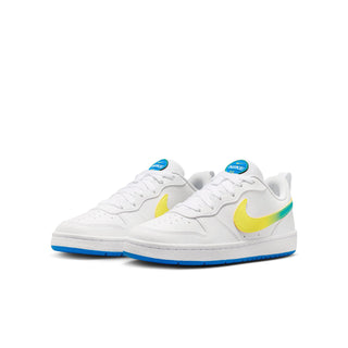 Youth low-top sneakers pair, white uppers with yellow swooshes, teal accents, blue outsole
