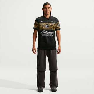 Mens black soccer jersey with gold crest stripe, short sleeves, Caliente.mx center graphic