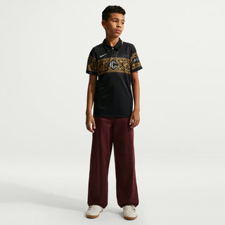Youth black soccer jersey with gold patterned shoulders and polo collar