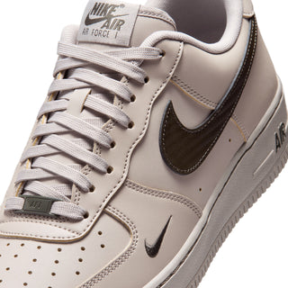 Men's low-top sneaker close-up, light beige laces and dark Swoosh on side panel