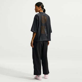Black jersey T-shirt worn with wide-leg pants, showing back mesh panel