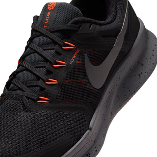 Men's black running shoe close-up, Flywire-style lacing with orange-red lines