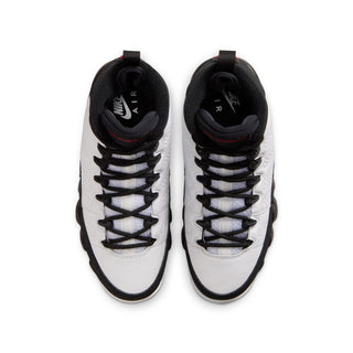 Pair of youth sneakers viewed from above, white leather with black laces and trim