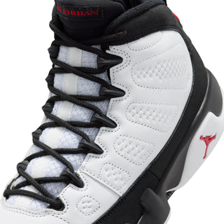 Close-up of youth sneaker laces on white upper with black overlays and red branding