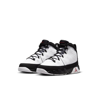 Kids high-top sneakers pair, white with black overlays and red heel detail, front angle.