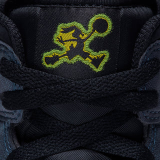 Close-up of tongue area on navy mid-top sneakers with neon green basketball graphic