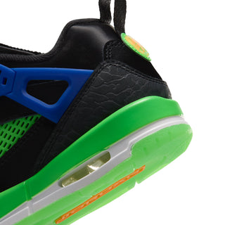 Youth low-top sneaker side close-up with textured black panel, blue accents, and green midsole